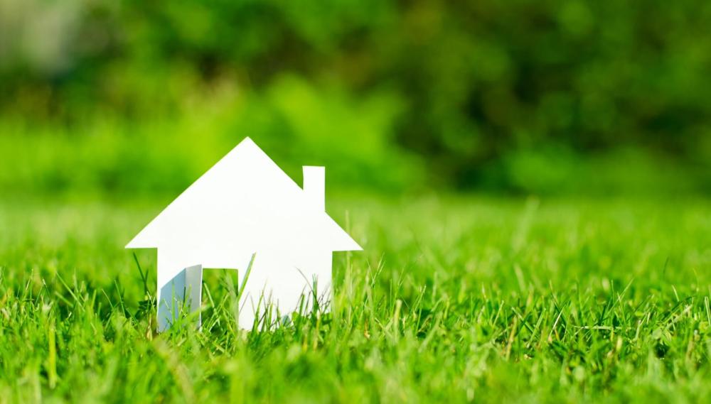 Maison en papier sur de l'herbe
